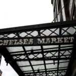 a sign for a cheese market hanging from a building